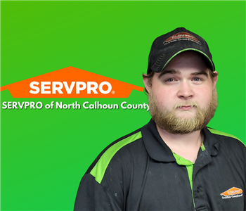 Caucasian young gentleman in black and green shirt with sandy blonde beard. With Green back ground and SERVPRO logo. 